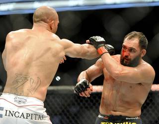 Johny Hendricks blocks a punch from Robbie Lawler during a UFC 171 mixed martial arts welterweight title bout, Saturday, March 15, 2014, in Dallas. Hendricks won by decision.